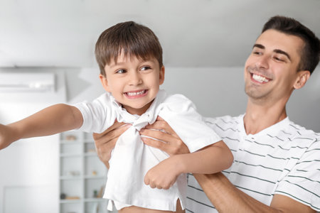 Man and his little son playing at homeの写真素材