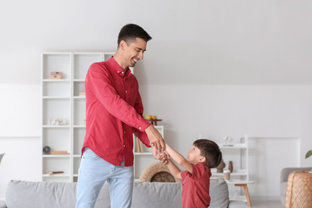 Man and his little son dancing at homeの写真素材