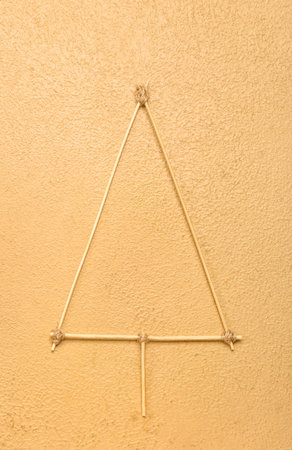 Christmas tree made of toothpicks on beige background