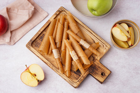 Wooden board with tasty apple pastilles on light backgroundの写真素材