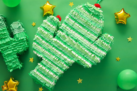 Mexican pinatas and balloons on green background
