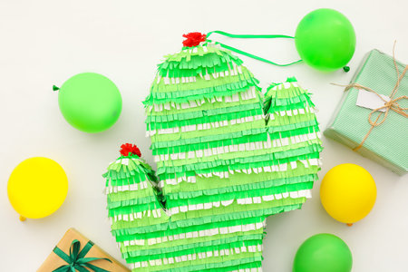 Mexican pinata in shape of cactus with gifts and balloons on white backgroundの写真素材