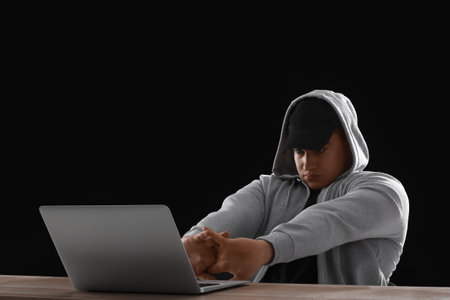 Hacker with laptop on dark backgroundの写真素材