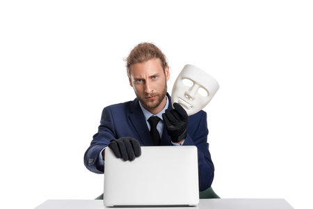Hacker with laptop and mask on white backgroundの写真素材
