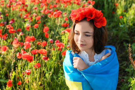 Little girl with Ukrainian flag in poppy fieldの写真素材