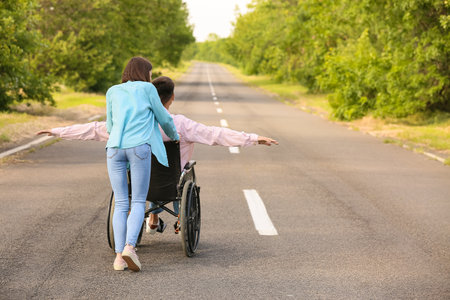 Young man with physical disability and his wife outdoorsの写真素材
