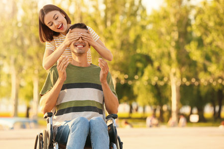 Young man with physical disability and his wife outdoorsの写真素材
