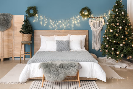Interior of bedroom with Christmas trees, wreaths and glowing lightsの写真素材
