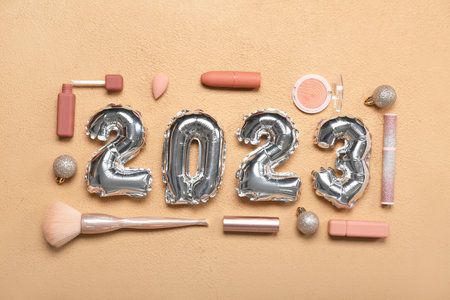 Figure 2023 made of balloons and makeup products on beige background