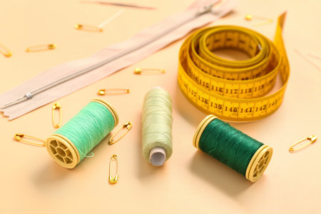 Set of sewing supplies with thread spools on color background, closeup