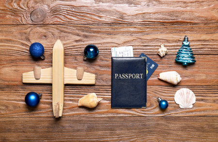 Passport with toy airplane, Christmas decor and seashells on wooden backgroundの写真素材
