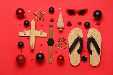 Travel accessories with Christmas decor and wooden airplane on red backgroundの写真素材