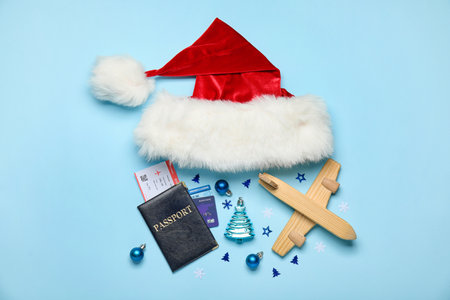 Passport with wooden airplane, Santa hat and Christmas decor on blue backgroundの写真素材