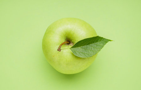 Ripe juicy apple on green backgroundの写真素材