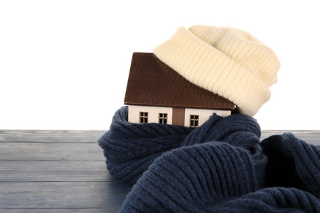 House model with hat and scarf on table against white background. heating conceptの写真素材