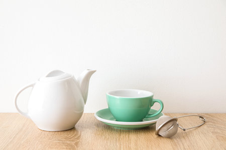 Stylish tea set on wooden table near light wallの写真素材
