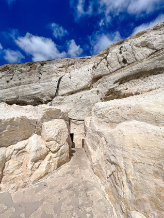 Pathway in high cliff against sky background