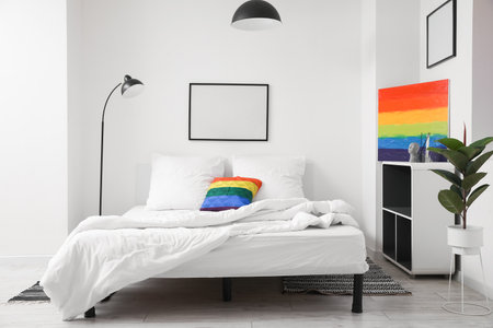 Interior of light bedroom with rainbow painting and pillowの写真素材