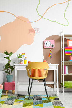 Stylish workplace with houseplants and rainbow flags near color wallの写真素材