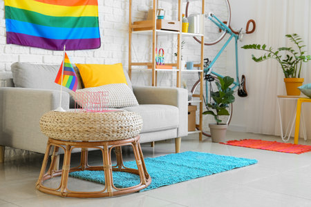 Comfortable sofa, pouf and rainbow flags in roomの写真素材