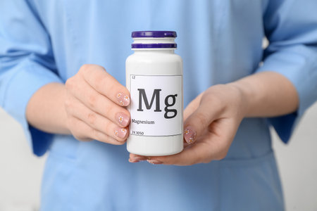 Female doctor holding bottle of magnesium pills, closeupの写真素材