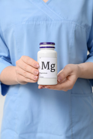 Female doctor holding bottle of magnesium pills, closeupの写真素材
