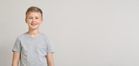 Portrait of smiling little boy on light background. Space for textの写真素材