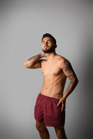 Handsome young man in underwear on gray backgroundの写真素材