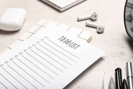 Empty to do list, earphones and stationery supplies on grunge table, closeup