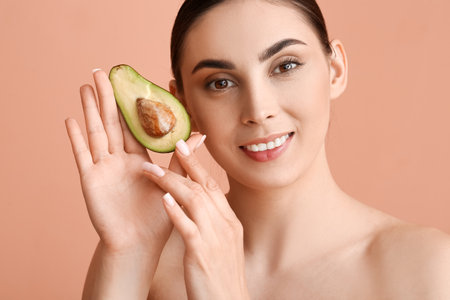 Beautiful smiling woman with fresh avocado on color background