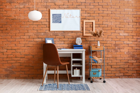 Room interior with stylish workplace and painting on brick wall with word NATUREの写真素材