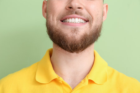 Young man with healthy gums on color background, closeupの写真素材