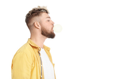 Young man chewing gum on white background