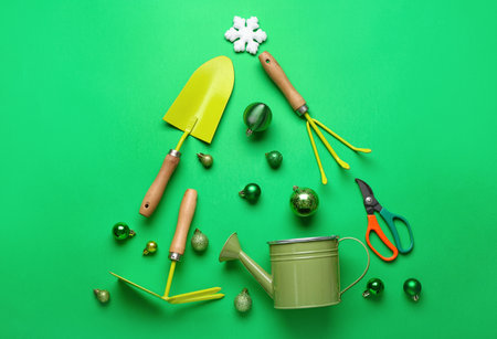 Christmas tree made of gardener tools and balls on green background