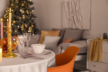 Christmas table setting with burning candles and balls in dining roomの写真素材