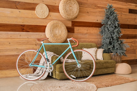 Interior of living room with bicycle, green sofa and Christmas treeの写真素材