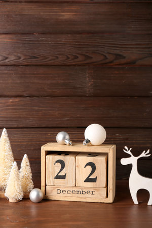 Cube calendar with date 22 DECEMBER and Christmas decor on dark wooden backgroundの写真素材