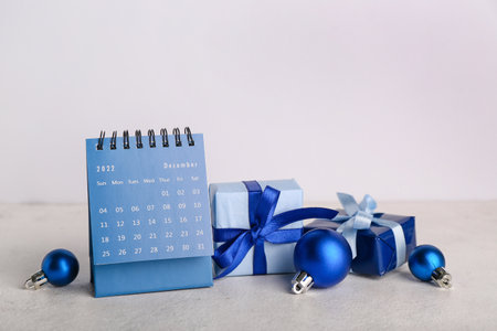Flip calendar for December 2022 with Christmas balls and gifts on light backgroundの写真素材