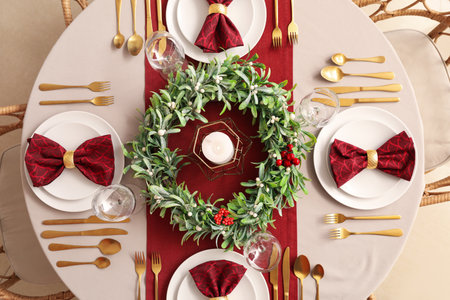 Christmas table setting with mistletoe wreath in dining roomの写真素材