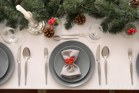 Christmas table setting with fir branches and rowan in dining room, top view