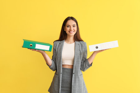 Beautiful young woman with folders on color backgroundの写真素材