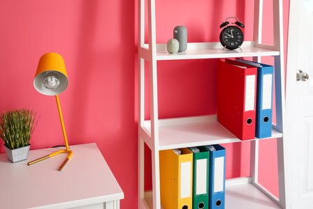 Shelf unit with folders near color wallの写真素材
