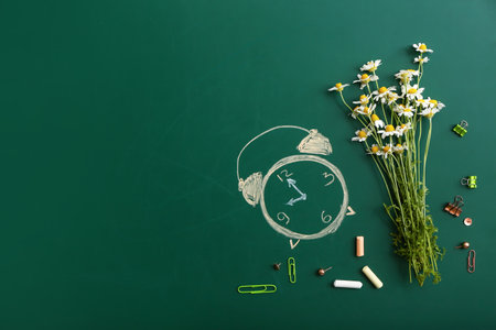 Drawn alarm clock and chamomile flowers on color backgroundの写真素材