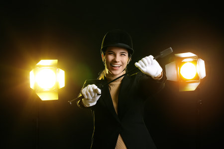 Happy female jockey on dark background