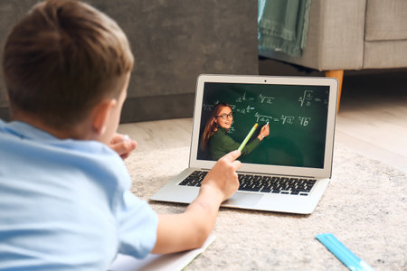 Little boy studying Math online at home
