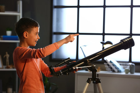 Little boy with telescope looking at the stars in the eveningの写真素材