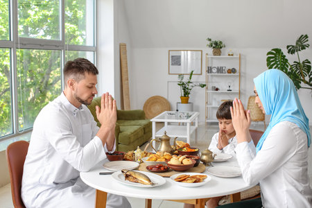 Muslim family praying together before breakfast. Celebration of Eid al-Fitrの写真素材