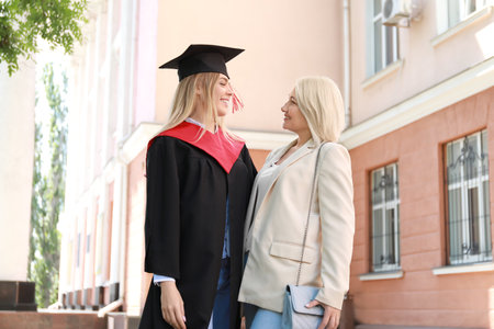 Happy young woman with her mother on graduation dayの写真素材