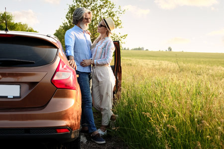 Happy mature couple near car in countrysideの写真素材