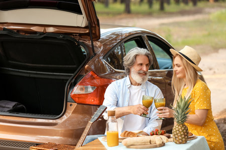 Happy mature couple having picnic in forestの写真素材